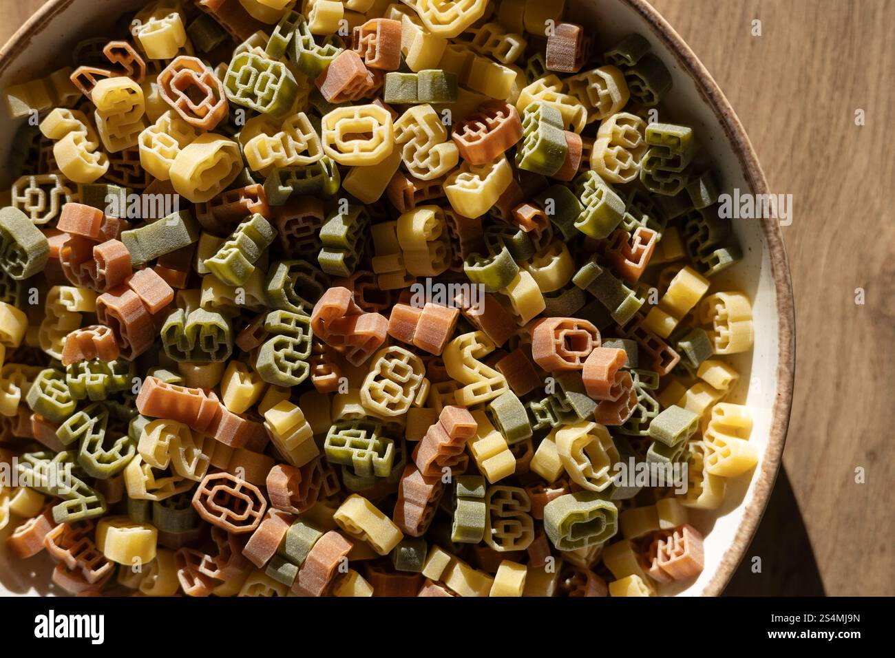 Una ciotola ripiena di pasta multicolore a forma di numeri con varie cifre. I numeri non sono abbastanza chiari per identificare un anno specifico. Foto Stock