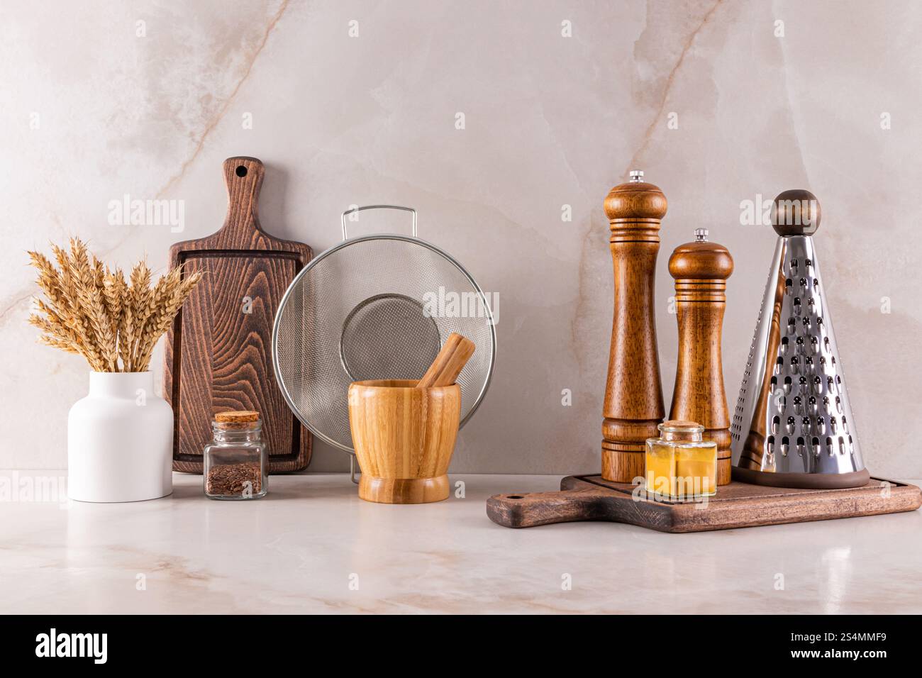 Eleganti utensili da cucina disposti su un ripiano in marmo che riflette le tendenze moderne del design degli interni. Foto Stock