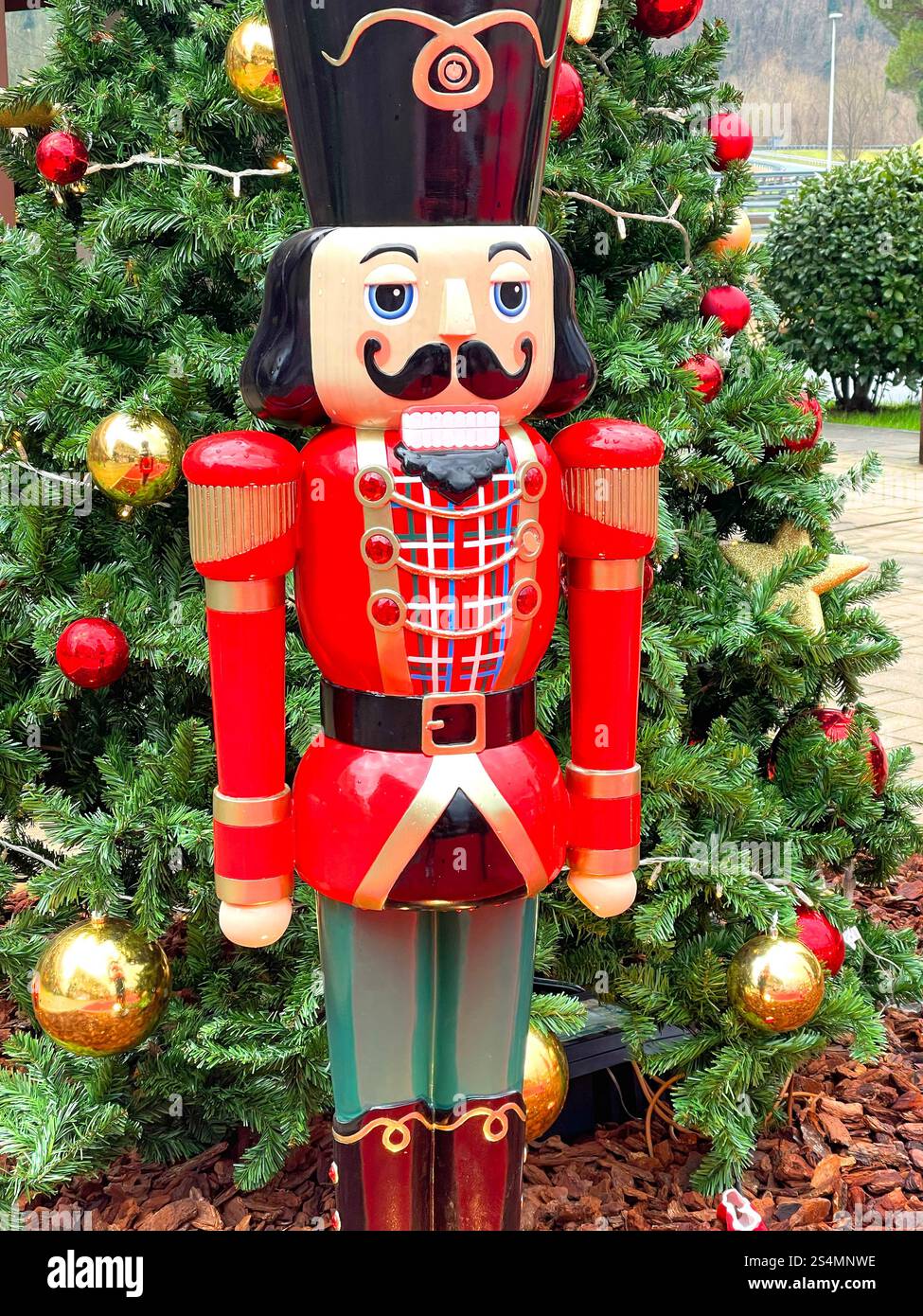 Composizione natalizia per strada. Albero di Natale decorato e noci di legno. Vacanze e decorazioni. Foto Stock