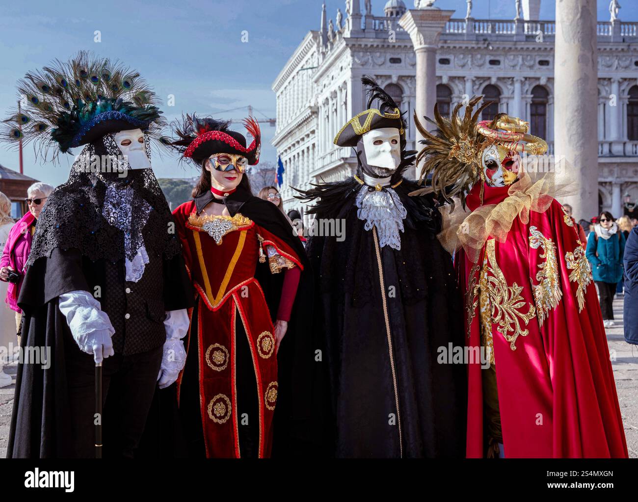 Colorato gruppo mascherato in vivaci costumi veneziani all'esterno Foto Stock