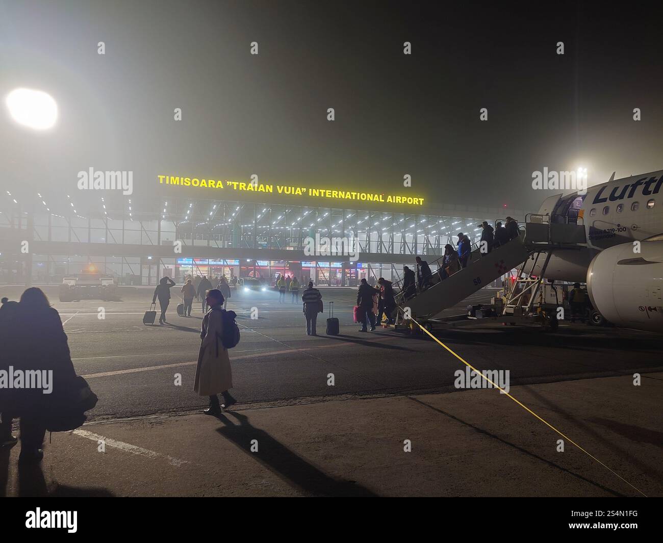 28-12-2024 Aeroporto Internazionale Timisoara Traian Vuia, Romania. Persone che sbarcano da un aereo airbus direttamente sulla pista in un inverno nebbioso Foto Stock