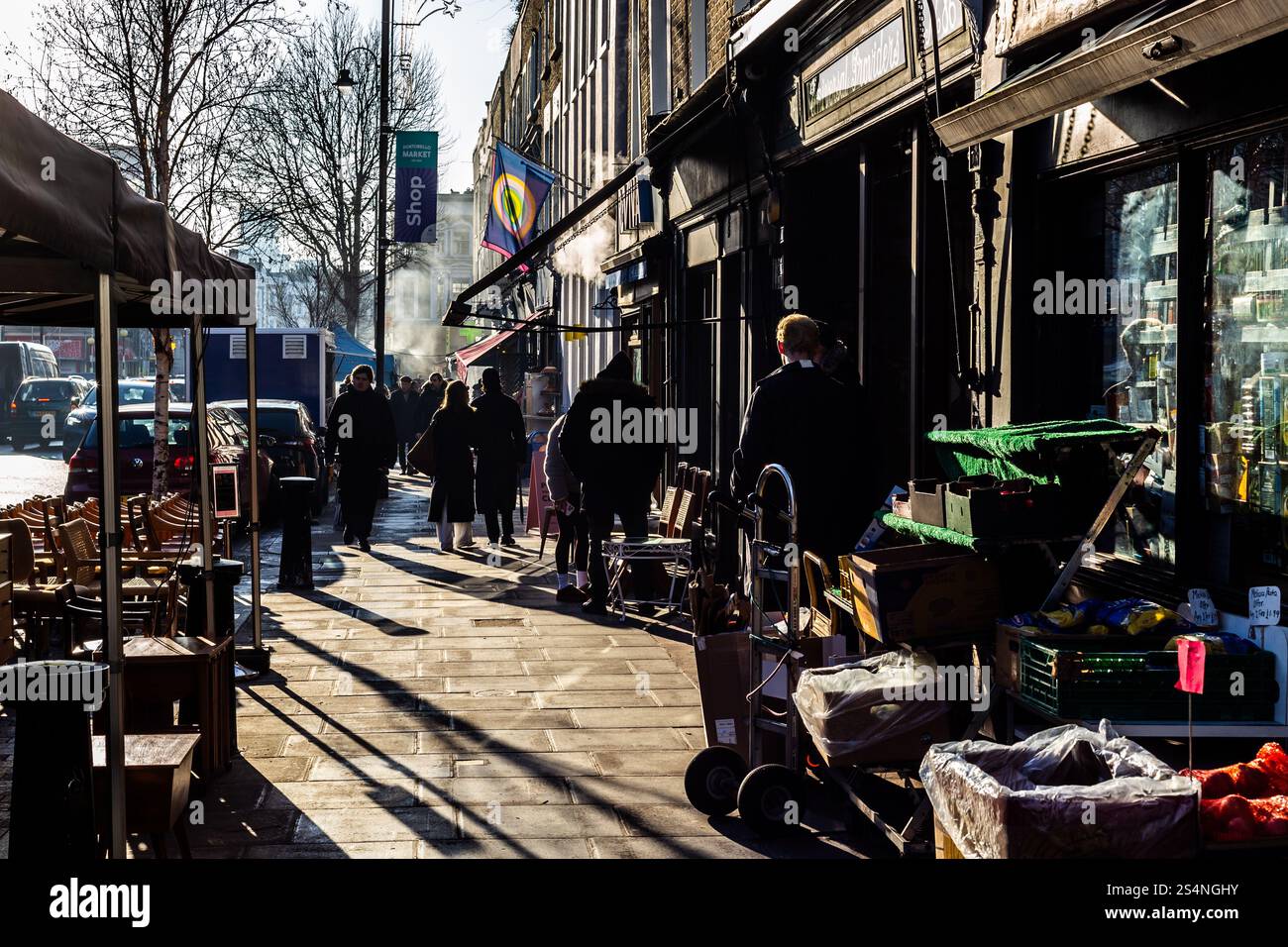 Sole luminoso in una visita del fine settimana a Golborne Road nella parte ovest di Londra, vicino a Portobello Road. Una bella giornata con il sole che torna a illuminare la folla di persone. Foto Stock