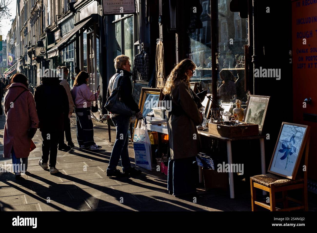 Sole luminoso in una visita del fine settimana a Golborne Road nella parte ovest di Londra, vicino a Portobello Road. Una bella giornata con il sole che torna a illuminare la folla di persone. Foto Stock