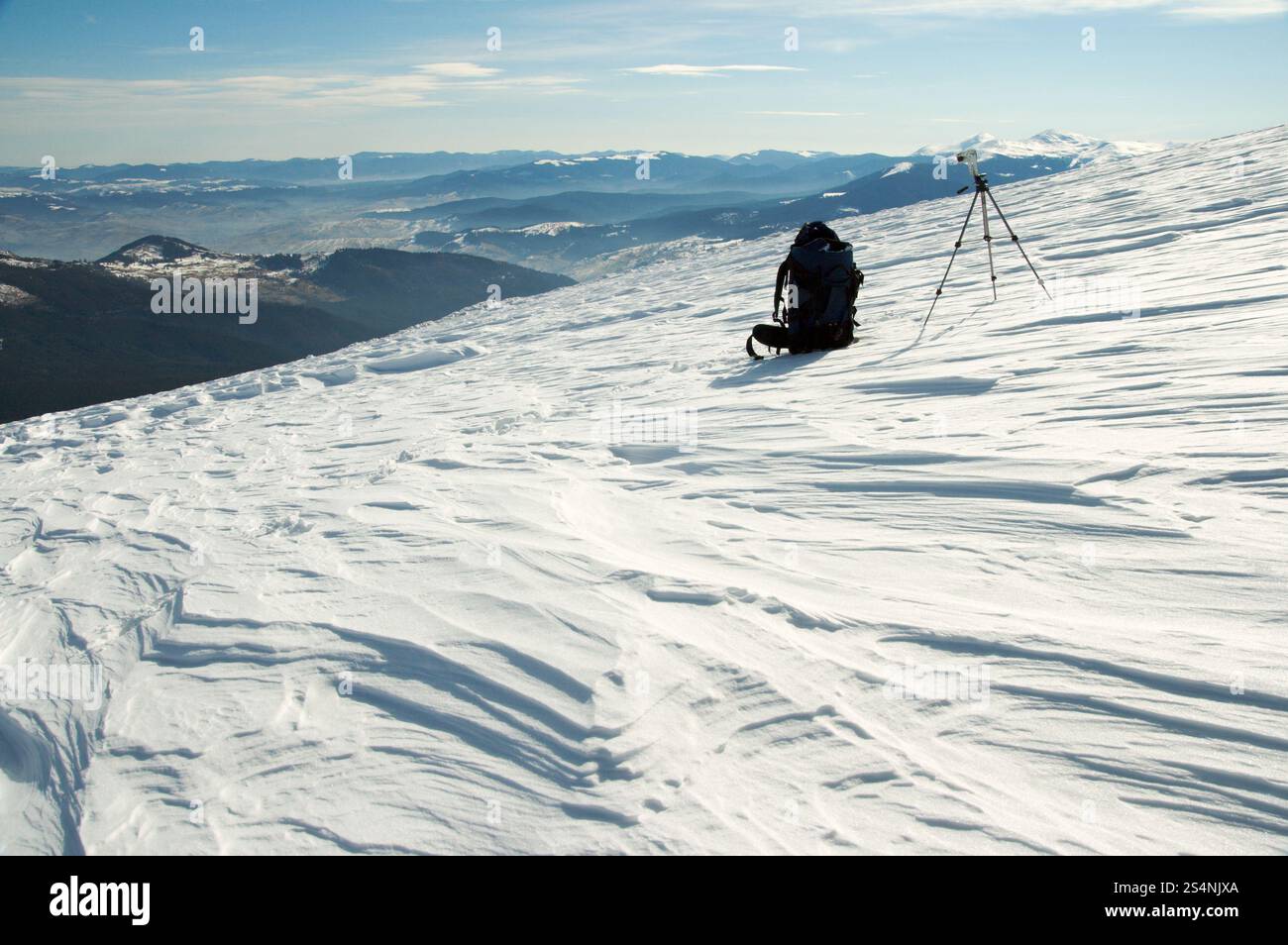 Paesaggio montano invernale con zaino turistico e treppiede fotografico (Ucraina, Carpazi MTS, Goverla e montagne Petros dietro) Foto Stock