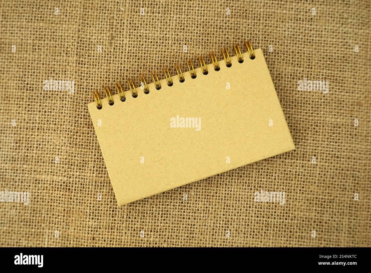 Quaderno a spirale vuoto su sfondo burlap Foto Stock