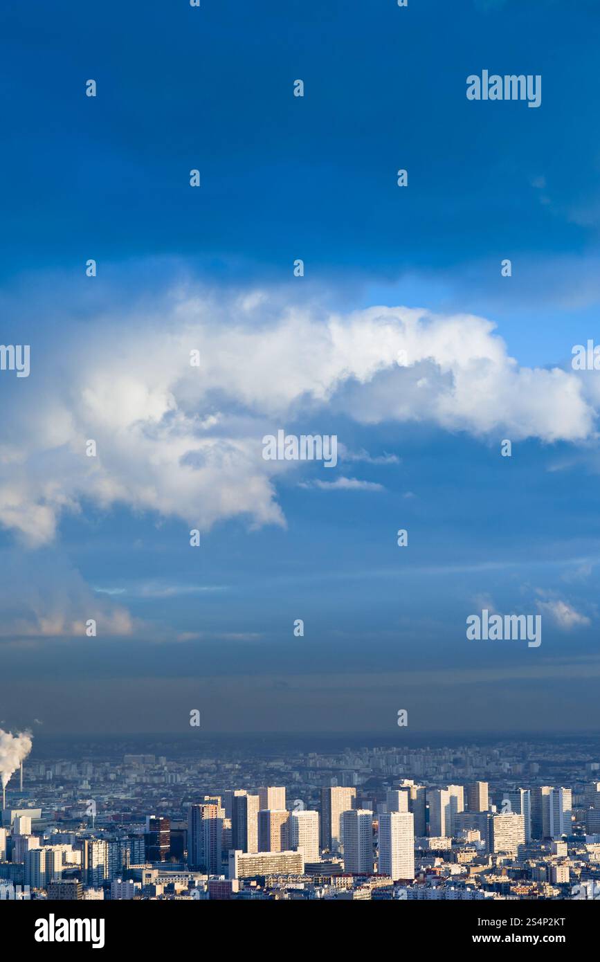 Grande città sotto alto cielo blu con nuvole bianche Foto Stock