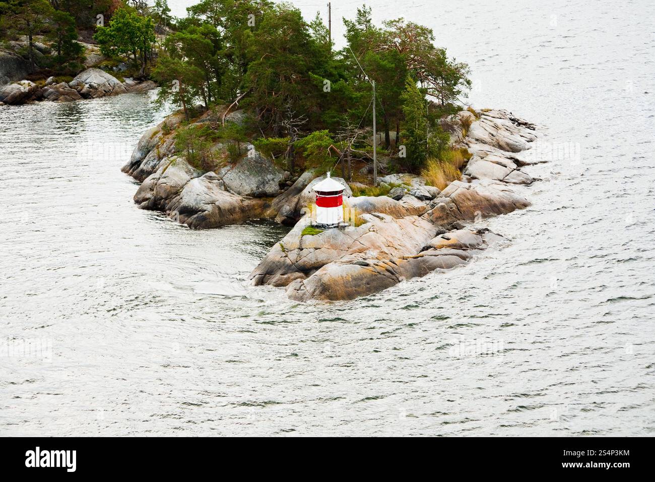Piccolo faro sulla isola di pietra nel fiordo svedese Foto Stock