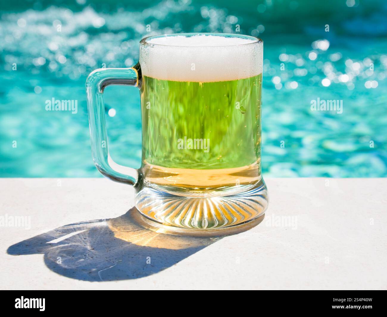 Bicchiere di birra fredda a bordo piscina in caldo giorno d'estate Foto Stock
