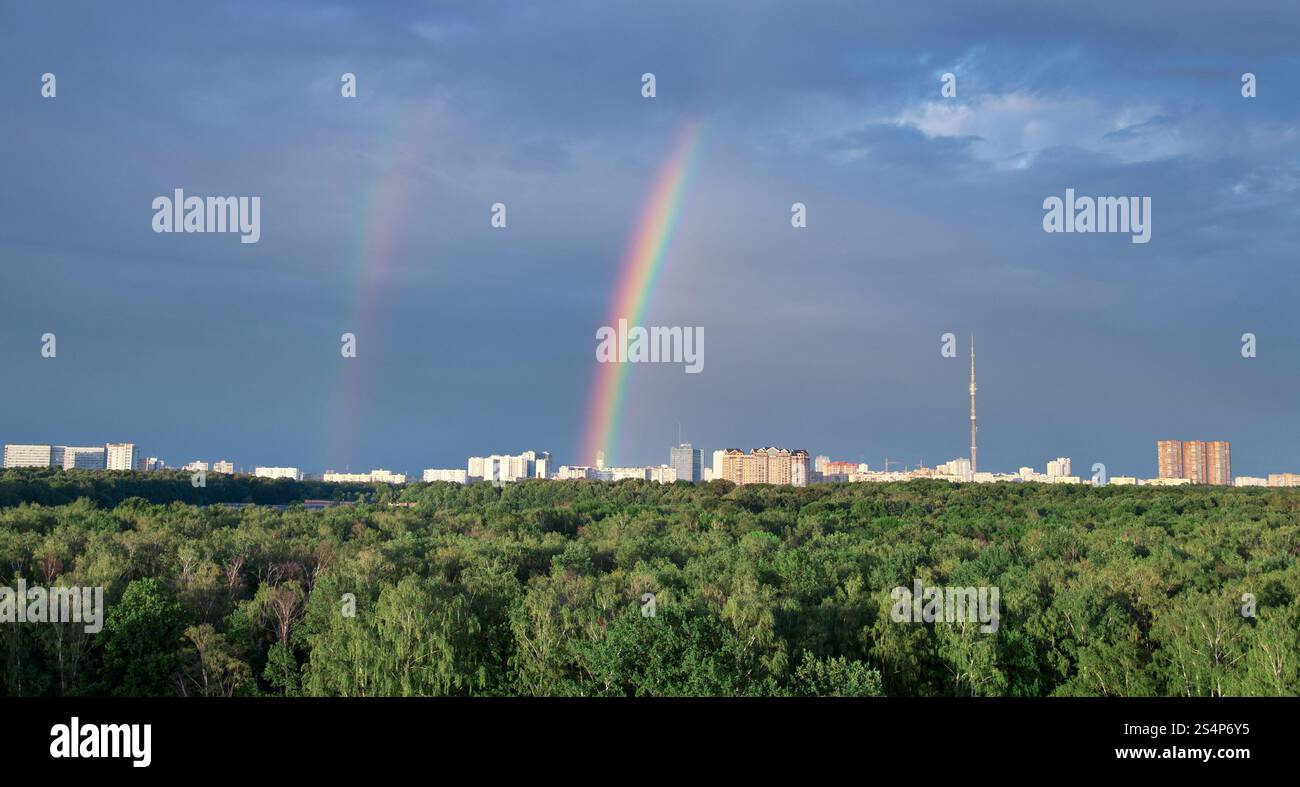 Paesaggio urbano con doppio arcobaleno sotto il parco della città Foto Stock