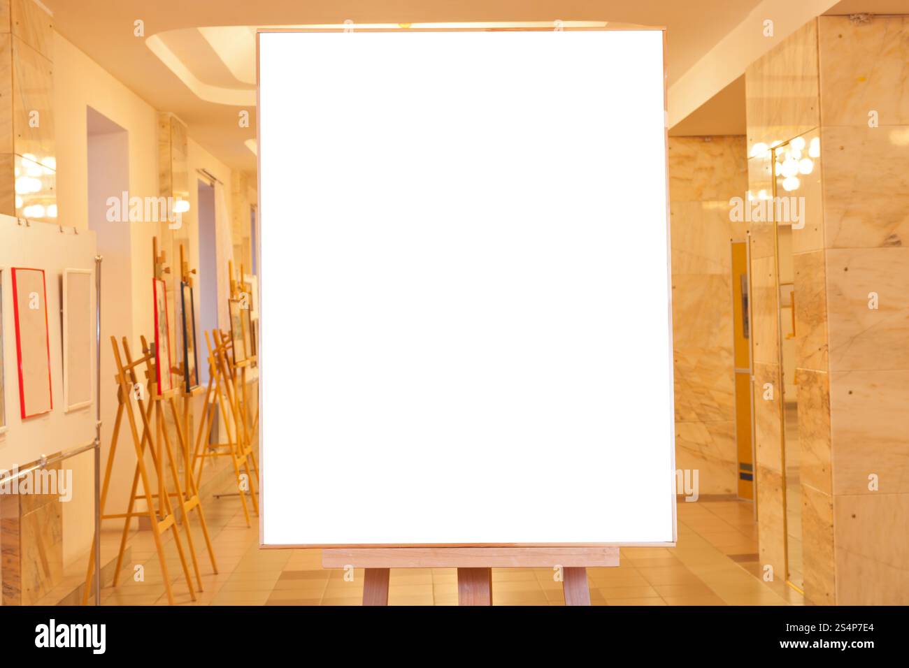 Big Picture Frame con taglio bianco su tela su cavalletto con luce gialla sfondo gallery Foto Stock
