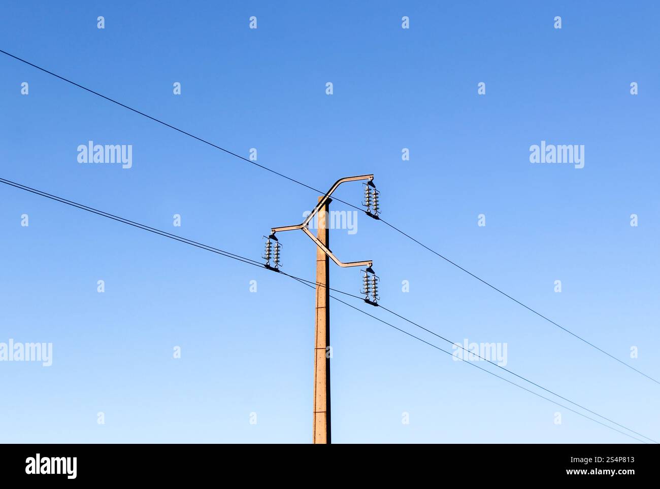 Strommast mit Stromleitungen zur Energieversorgung vor einem blauen Himmel nella regione einer ländlichen a Frankreich. Foto Stock