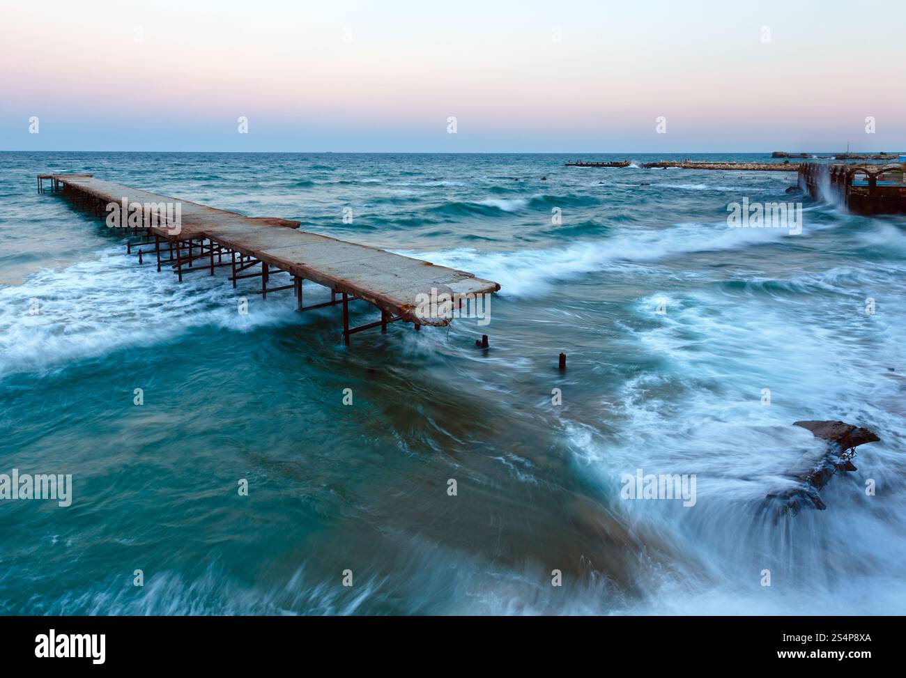 Di sera la tempesta di mare e rovinato pier (Mar Nero, Bulgaria). Foto Stock