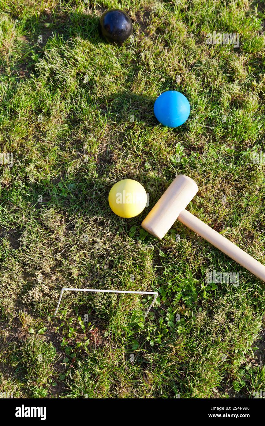 vista dall'alto delle palle e del mazzuolo per giocare a croquet sul prato verde nei giorni estivi Foto Stock