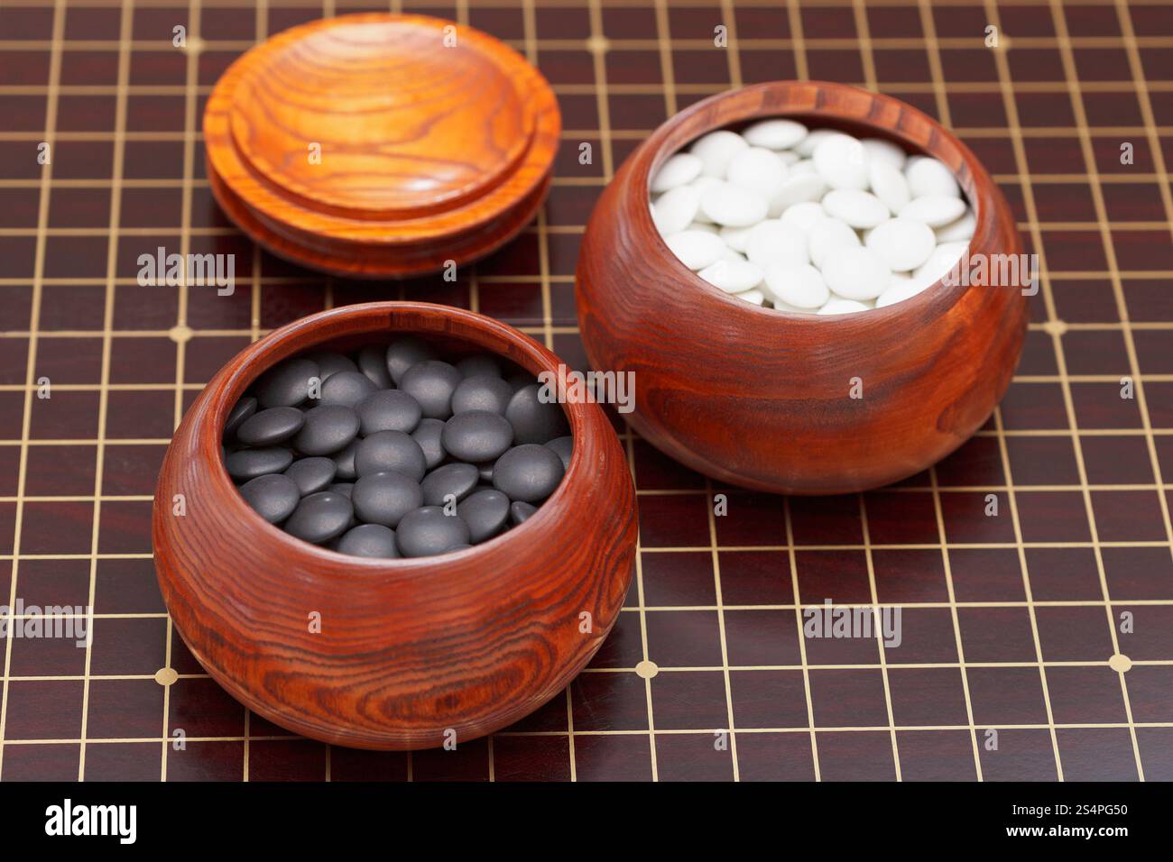 Bianco e nero gioco go pietre in ciotola di legno Foto Stock