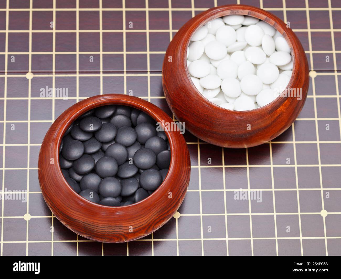 Set di bianco e nero gioco go pietre in ciotole di legno Foto Stock