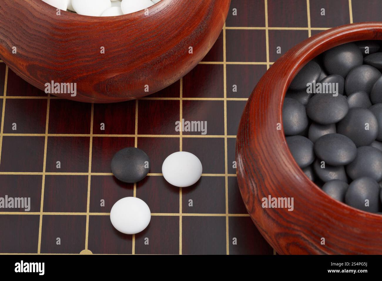 Bianco e nero gioco go pietre e ciotole di legno sul goban Foto Stock