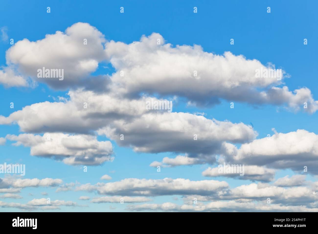 Il bianco e il grigio puffy nuvole nel cielo blu nel pomeriggio a molla Foto Stock