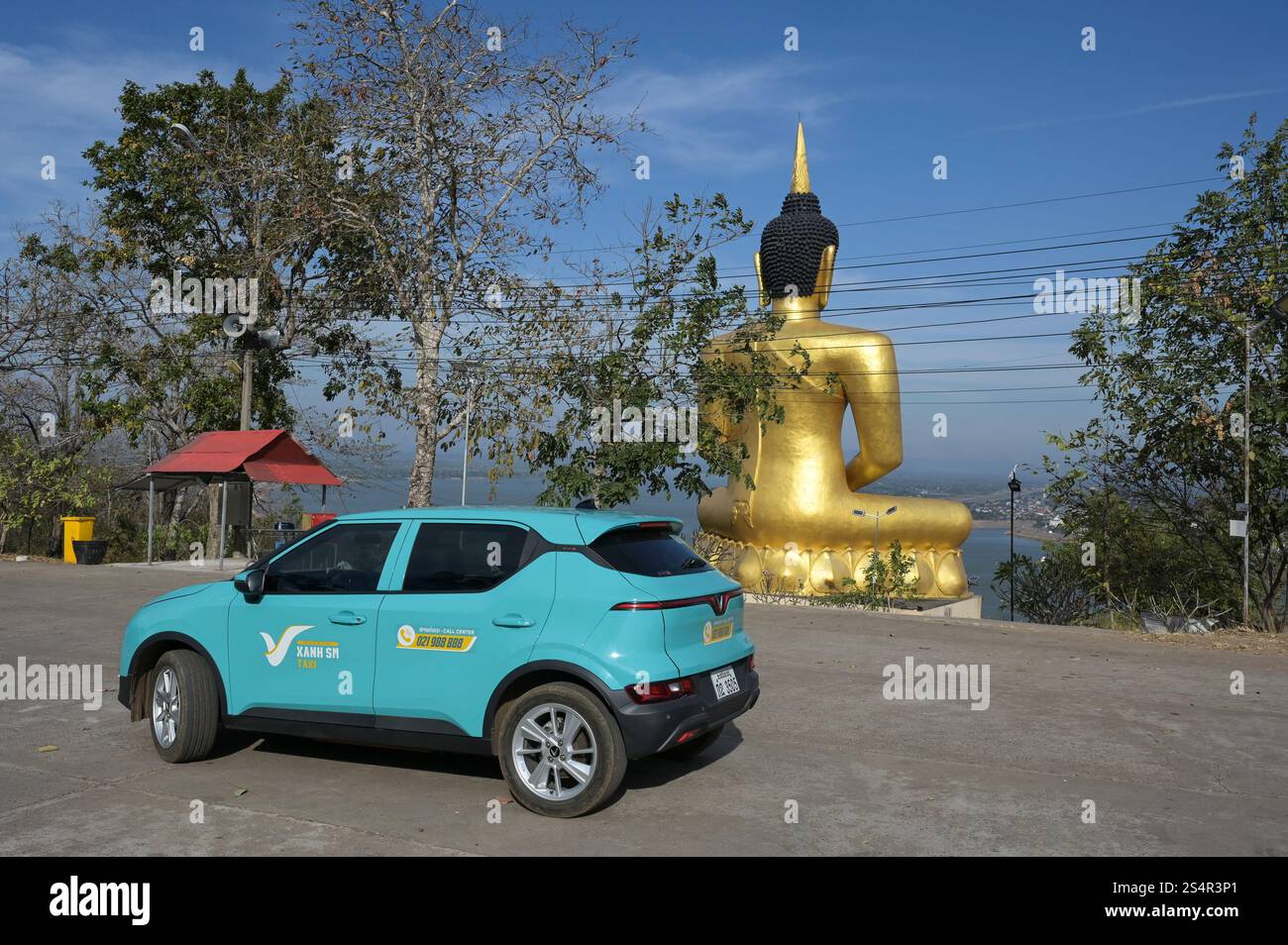LAO P.D.R., Pakse, Golden Buddha at Wat Phou Salou, vietnamita Vinfast Electric car of APP taxi Company Xanh SM of vietnamese Vin Group / LAOS, Pakse, Goldene Buddha Statue am Wat Phousalao, vietnamesisches Elektroauto VinFast des App taxi Unternehmen Xanh SM der Vin Group in Vietnam, das Auto kann per App digital bestellt werden Foto Stock