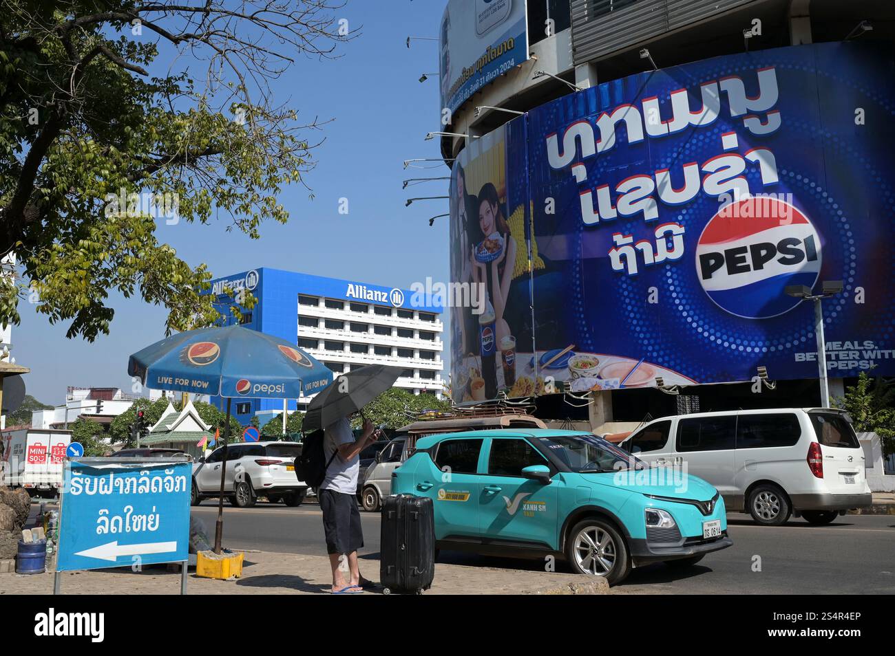 LAO P.D.R., Vientiane, vietnamita Vinfast auto elettrica di APP taxi Company Xanh SM di vietnamita Vin Group, dietro la compagnia assicurativa tedesca Allianz e Pepsi Cola ad Talat Sao shopping Mall / LAOS, Vientiane, vietnamesisches Elektroauto VinFast des App taxi Unternehmen Xanh SM der Vin Group in Vietnam Foto Stock