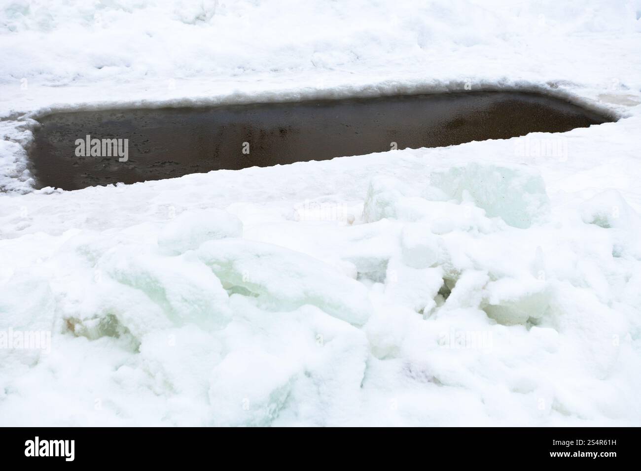 Glade con acqua congelata nel lago e blocchi di ghiaccio in inverno giorno Foto Stock