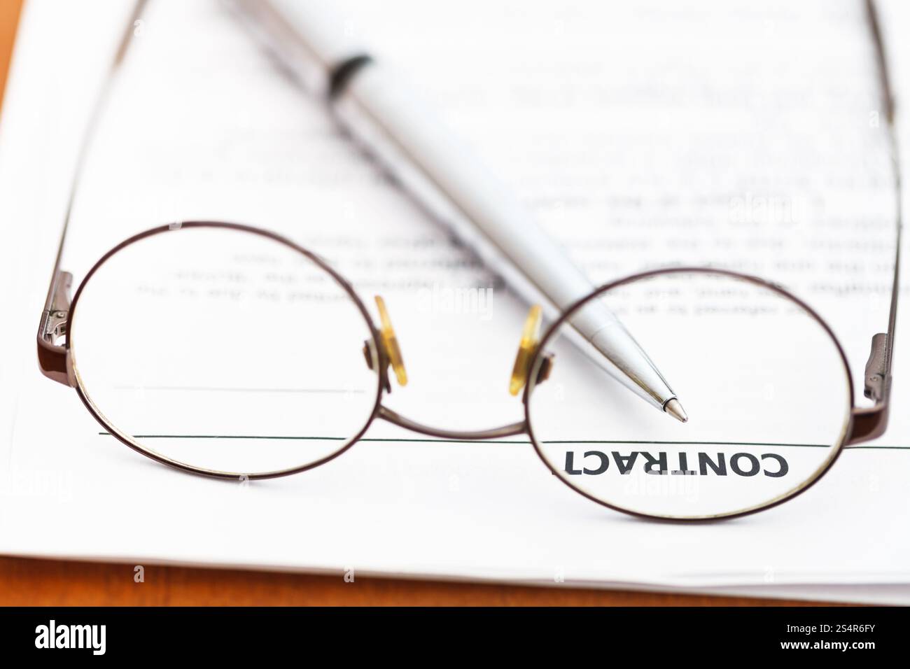 Contratto di vendita e la penna di argento attraverso occhiali Foto Stock