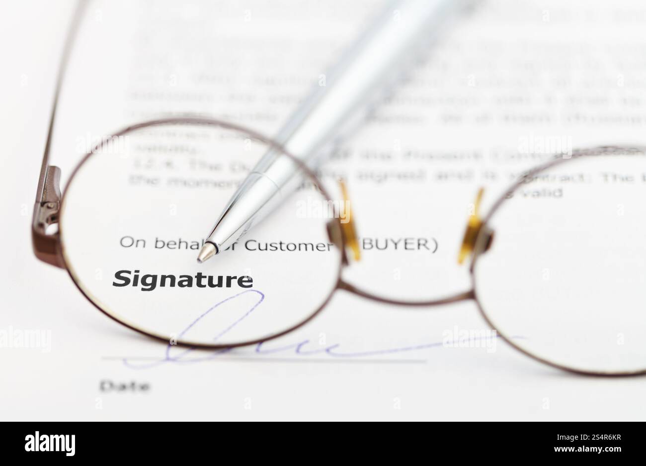 La firma del contratto di vendita e la penna di argento attraverso occhiali Foto Stock