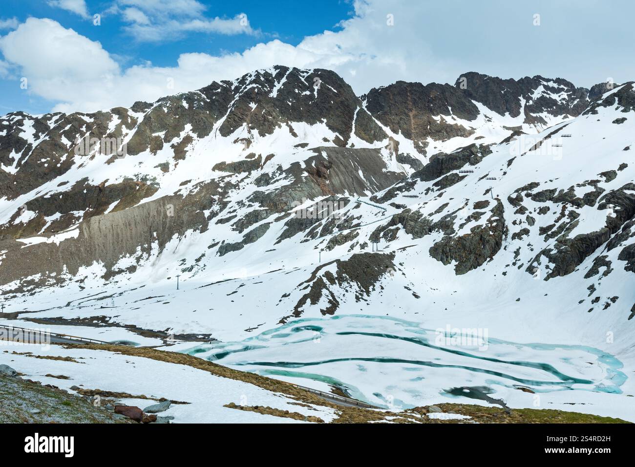 Strada in estate montagna delle Alpi e lago ghiacciato (Austria). Foto Stock