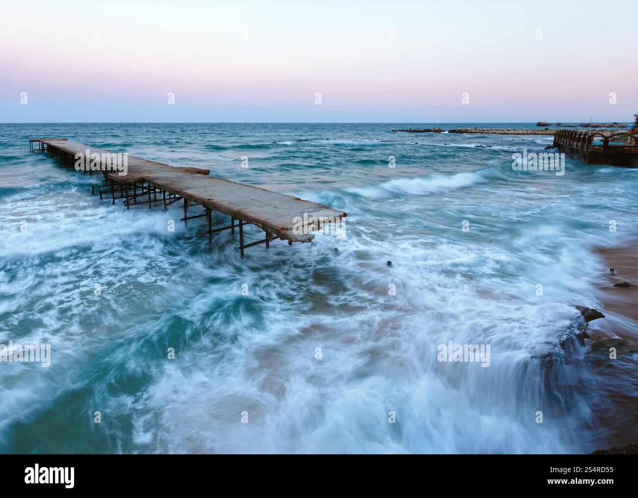 Di sera la tempesta di mare e rovinato pier (Mar Nero, Bulgaria). Foto Stock