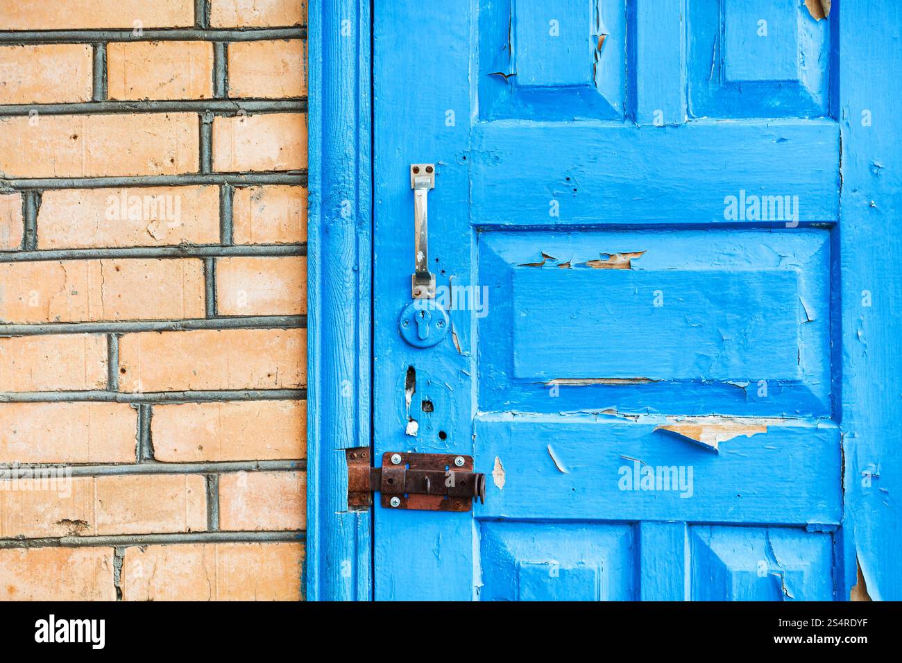 Dettagli della chiusa shabby blue porta di legno in un muro di mattoni Foto Stock