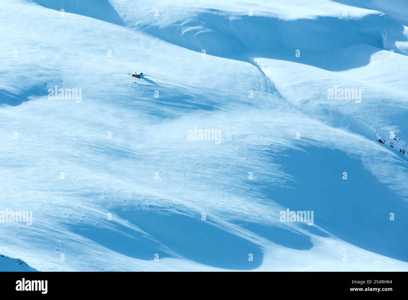 Piccola casa in legno sulla montagna invernale di pendenza. Foto Stock