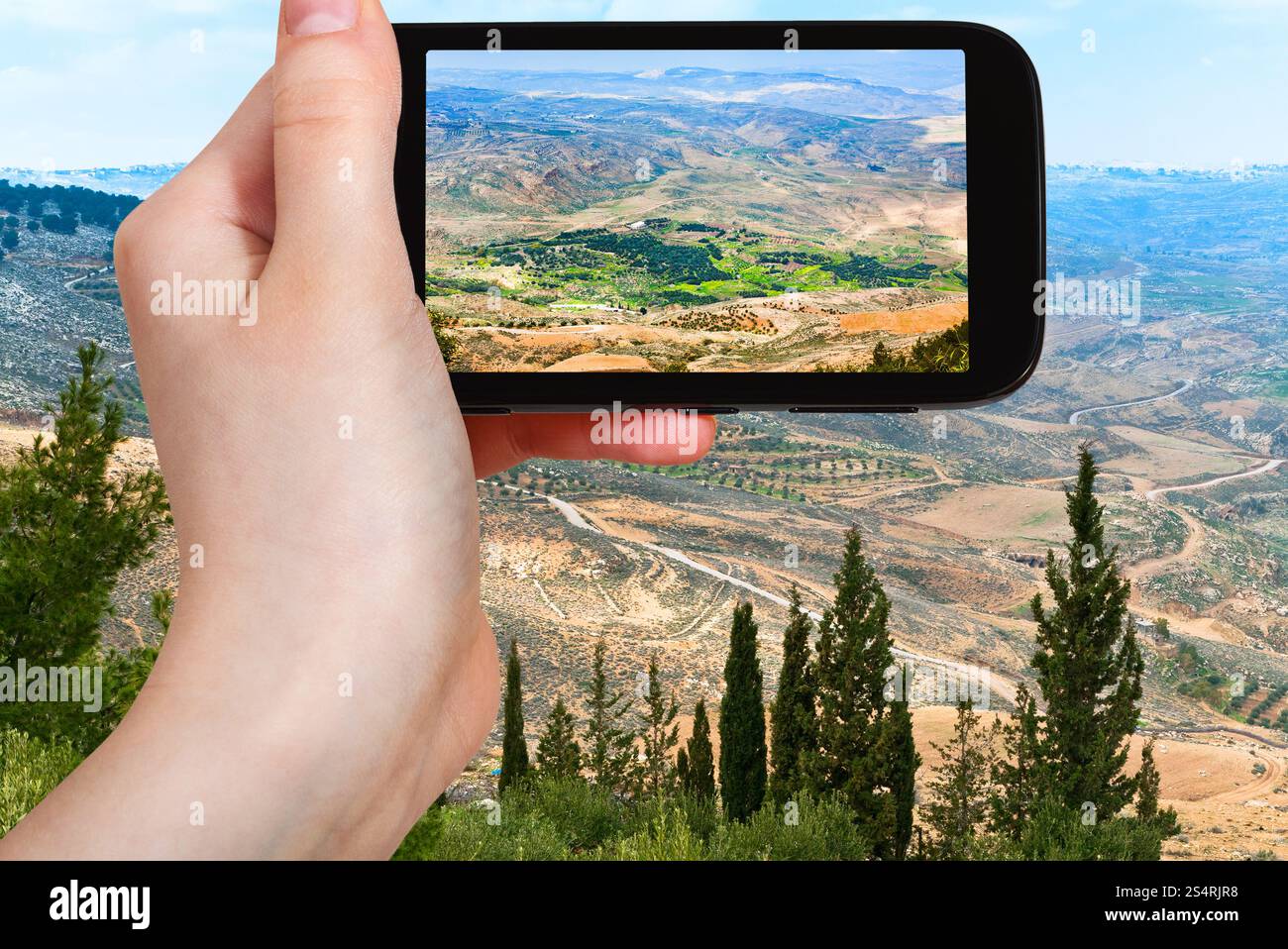 Concetto di viaggio - turistica prendendo foto della Terra Santa dal Monte Nebo in Giordania su gadget mobile Foto Stock
