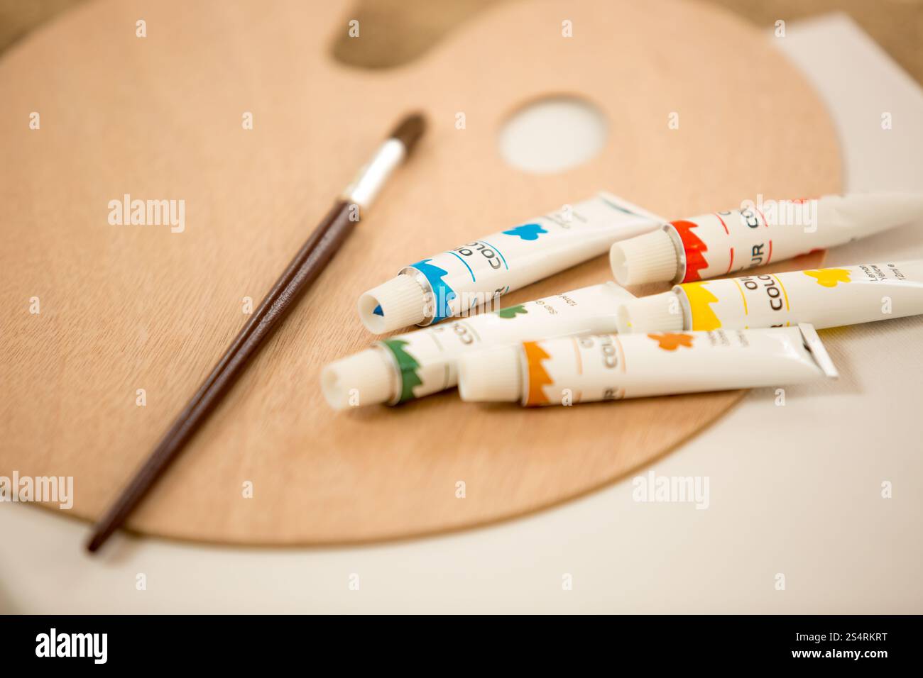 Macro shot della pittura a olio tubi un pennello giacente sulla paletta di colori Foto Stock