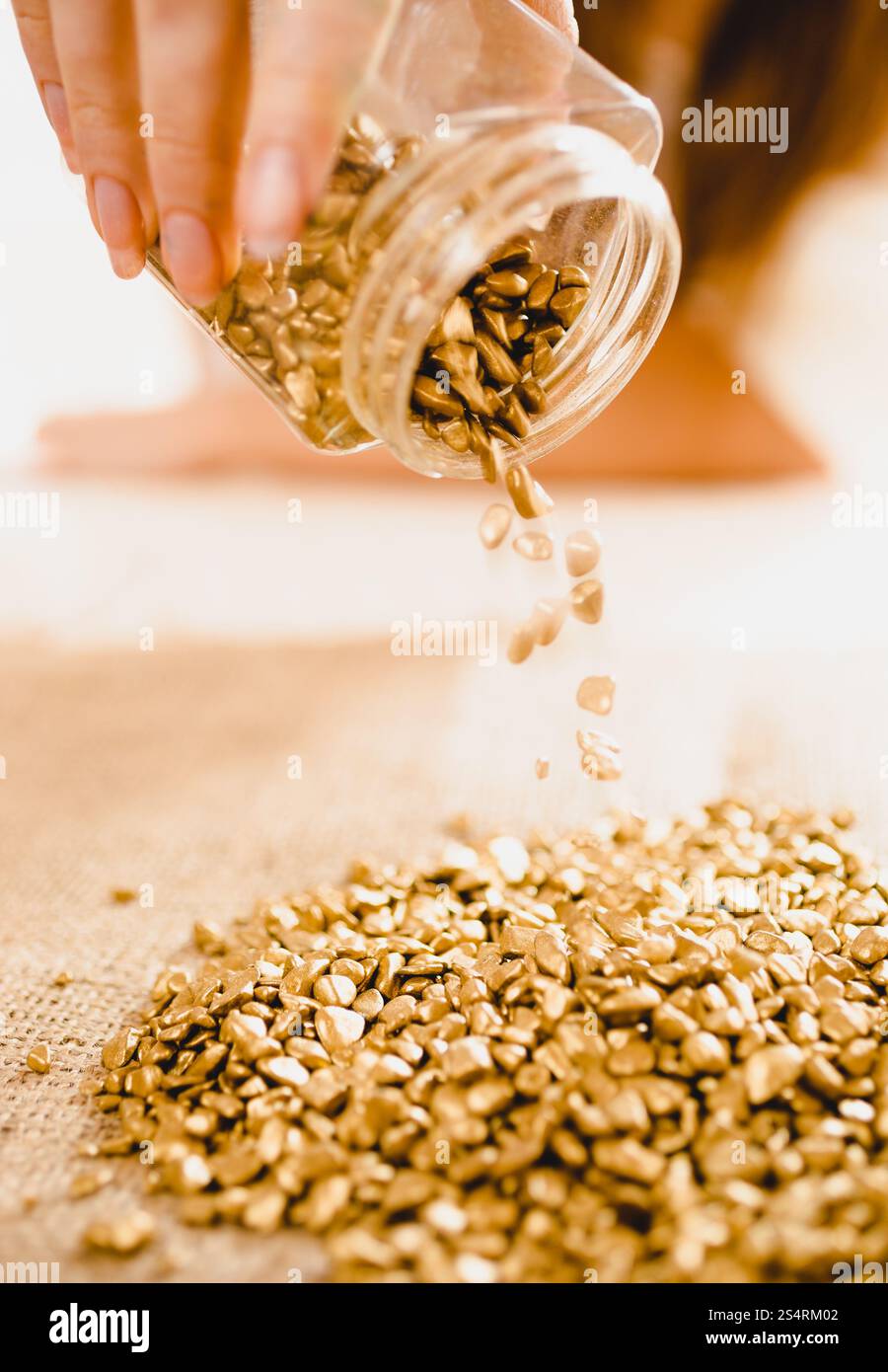 Foto concettuale di mano girando su bullion con pepite d'oro Foto Stock