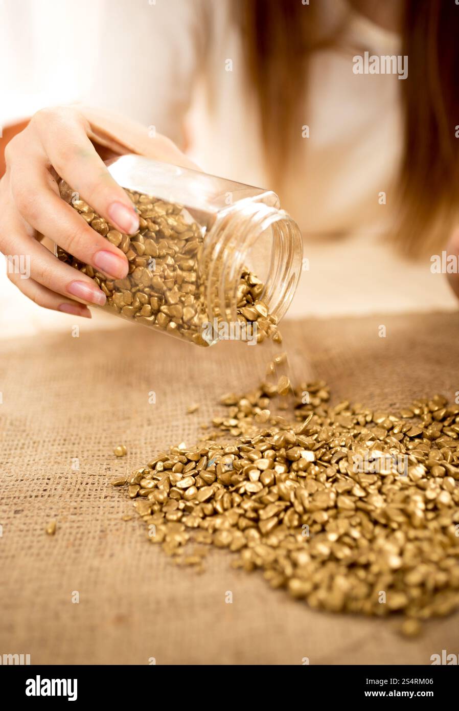 Primo piano della donna lo svuotamento bullion con oro su tela Foto Stock
