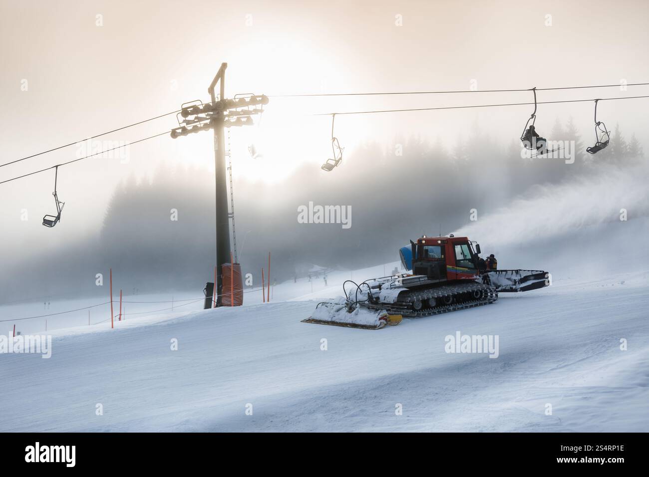 Silhouette foto di rimozione della neve macchina lavora su alta pista da sci a tempesta di neve Foto Stock