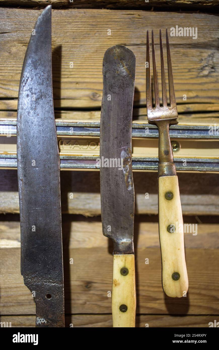 Primo piano di antichi utensili di metallo appeso alla parete in legno Foto Stock
