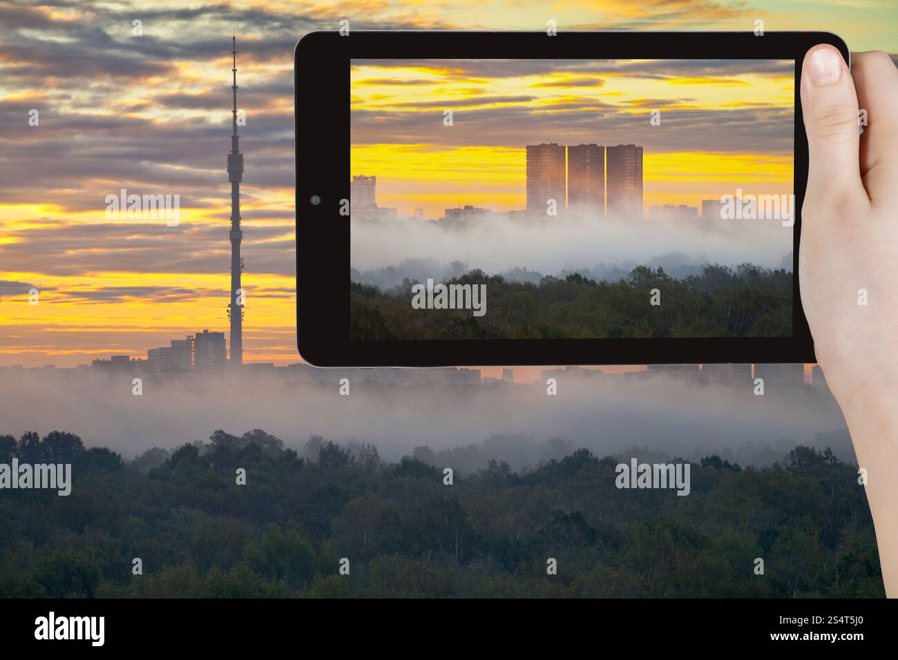 Concetto di viaggio - tourist prende foto di giallo sunrise e la nebbia di mattina in autunno città sullo smartphone, Mosca Foto Stock