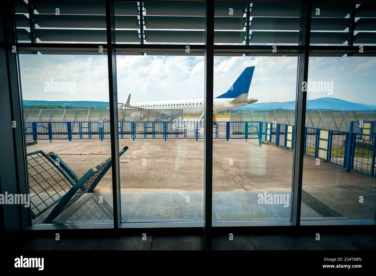 Vista dall'interno del terminal aeroportuale sul piano sulla pista Foto Stock