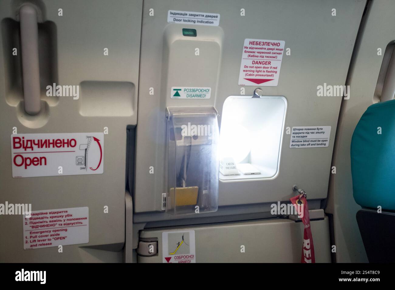 Foto di uscita di emergenza porta con oblò in aereo Foto Stock