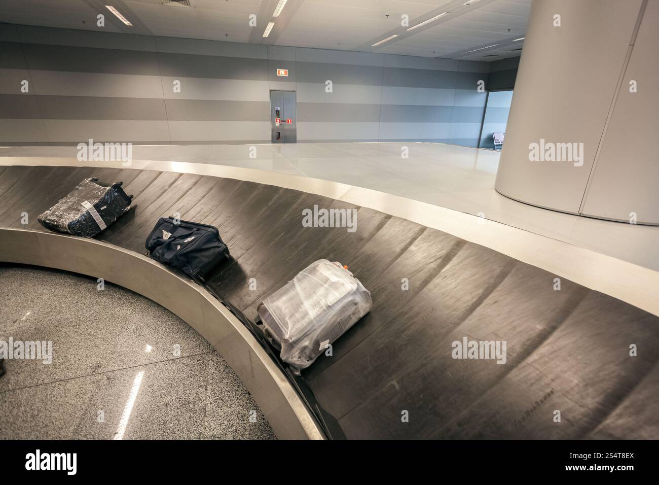 Il reclamo bagagli giostra con tre sacchetti a airport terminal Foto Stock
