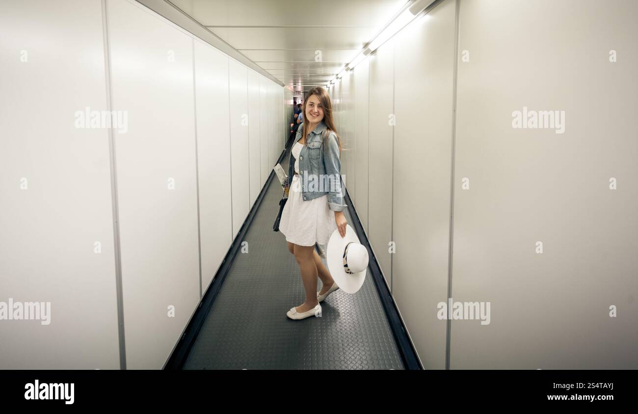 Bella donna con sacchi a piedi la porta di imbarco in aeroporto Foto Stock