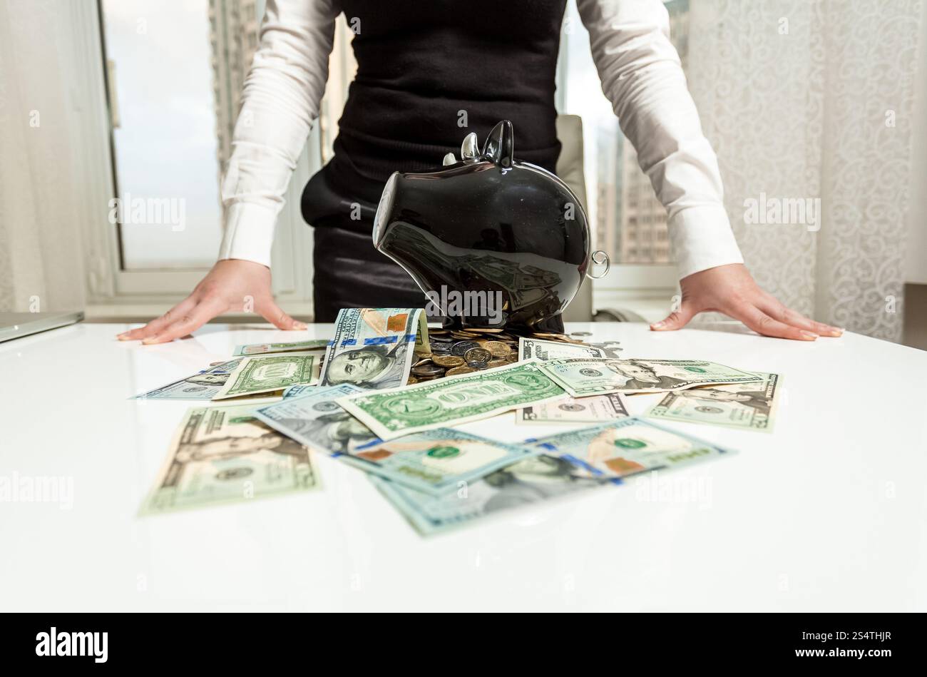 Business donna dietro la tabella con il salvadanaio e denaro Foto Stock
