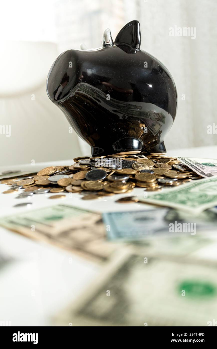Foto di nero salvadanaio permanente sulla pila di denaro Foto Stock