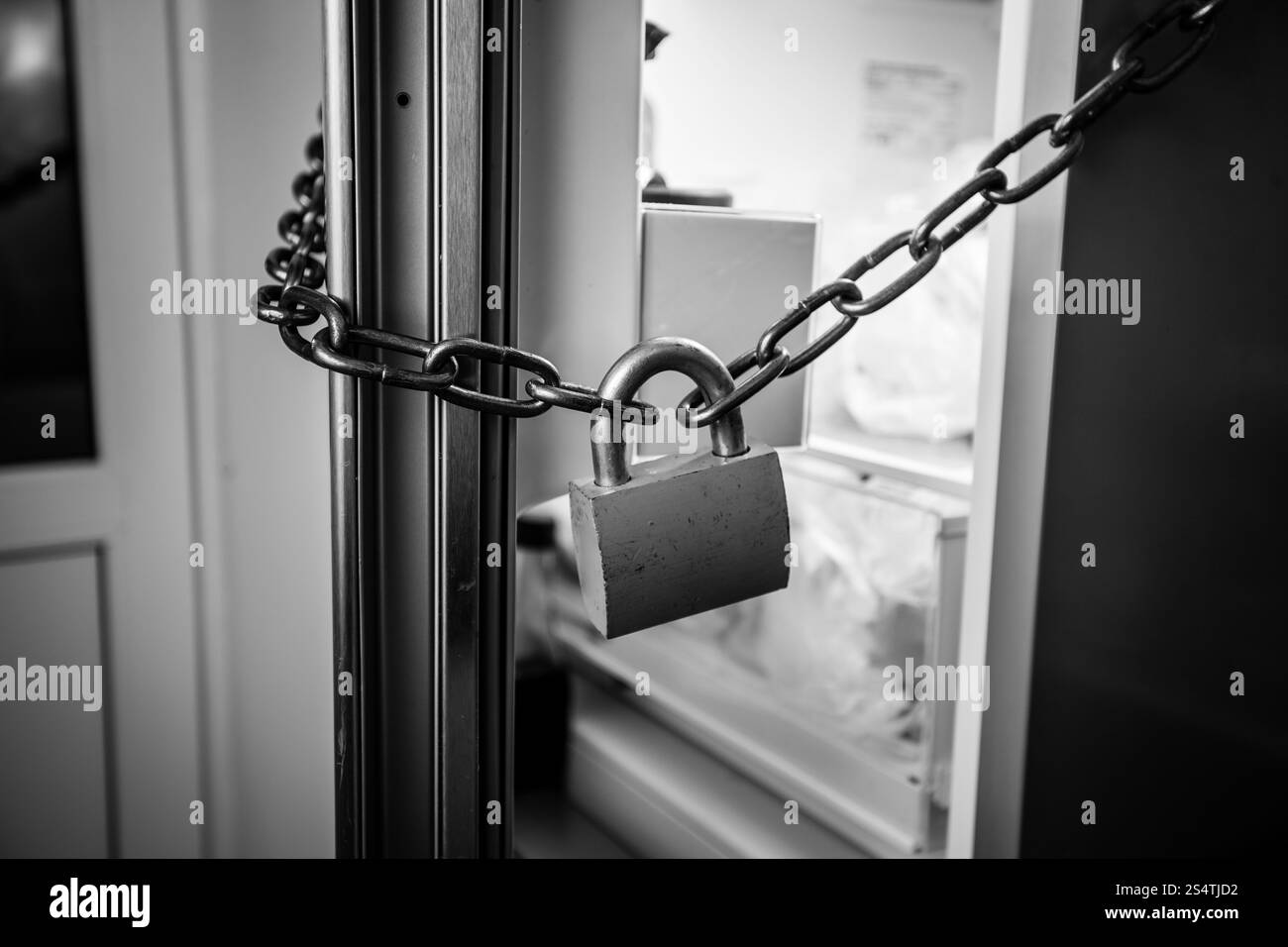 Foto in bianco e nero di frigo bloccato dalla catena Foto Stock