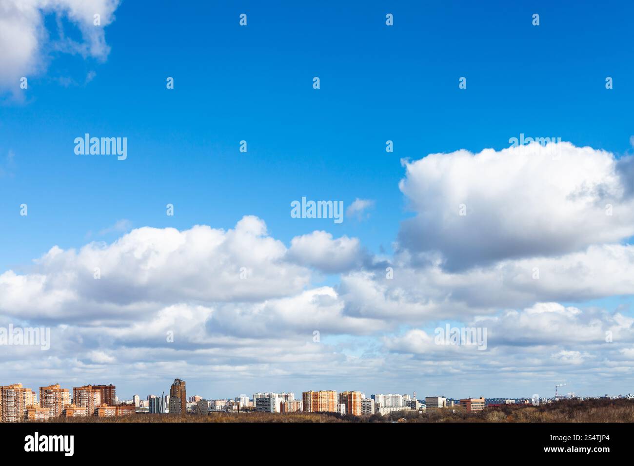 Puffy bianche nuvole nel blu del cielo di primavera sulla città Foto Stock