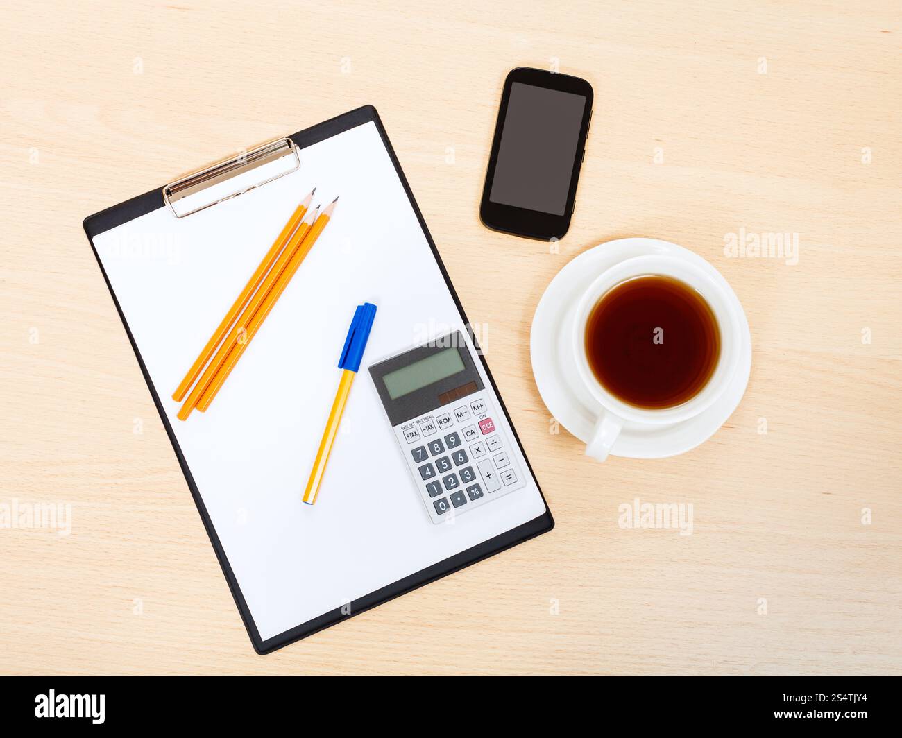 Business ancora vita - vista superiore di smartphone, Appunti, Calcolatrice, tazza di tè, penna e matita su tavola di office Foto Stock