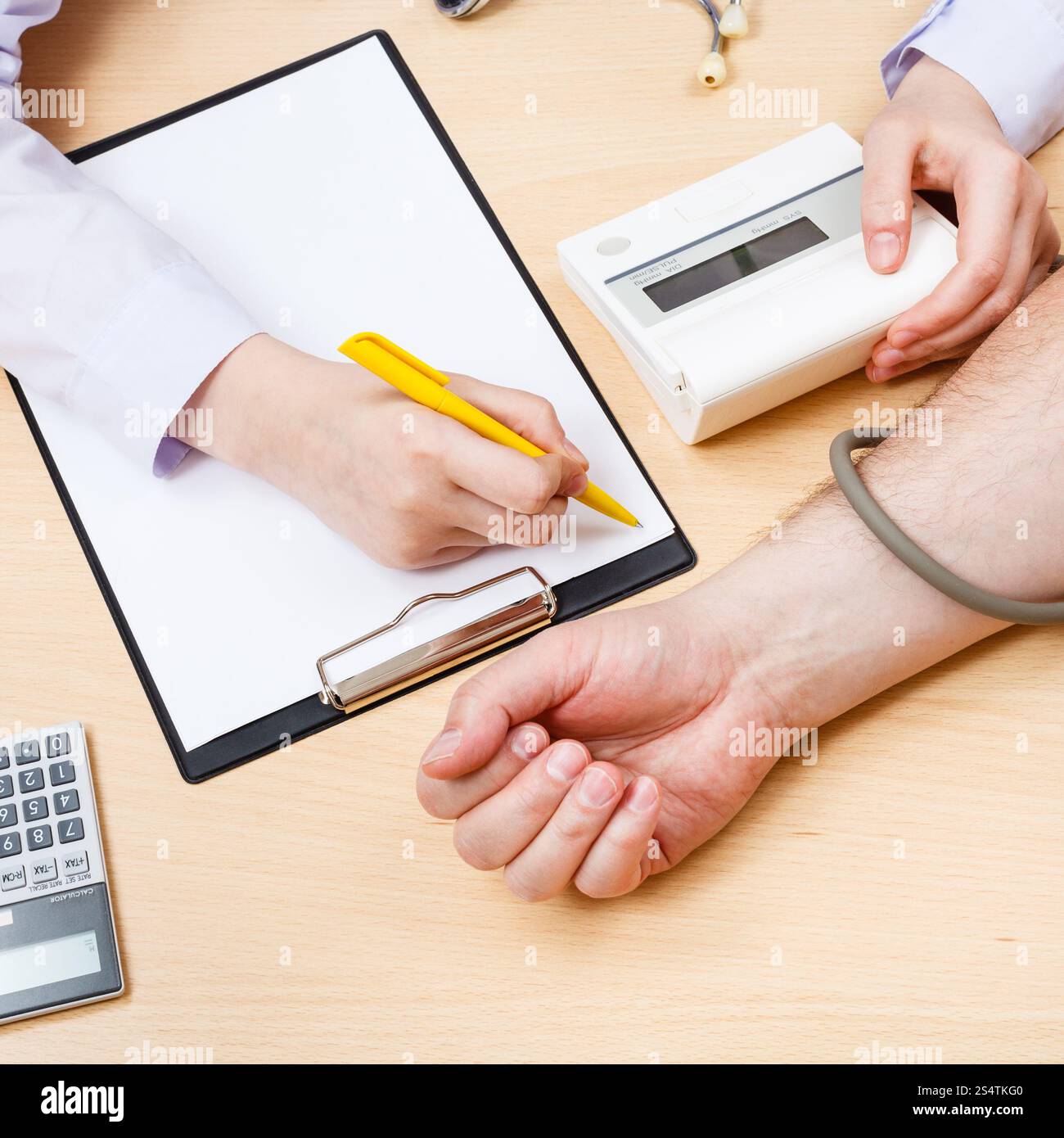 Medico misura la pressione del sangue del paziente durante l'appuntamento Foto Stock