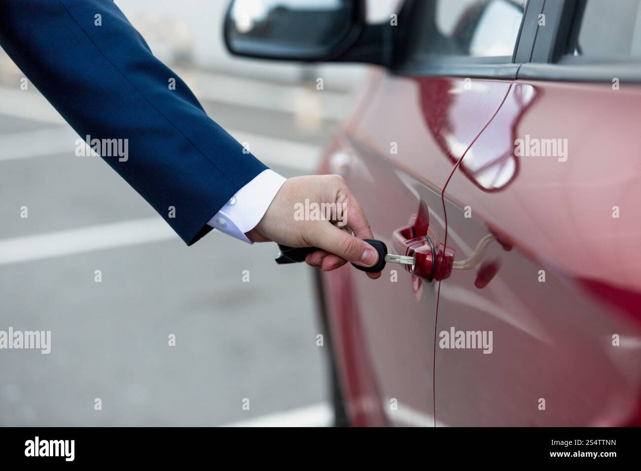 Closeup colpo di uomo in tuta auto apertura sportello con chiave Foto Stock
