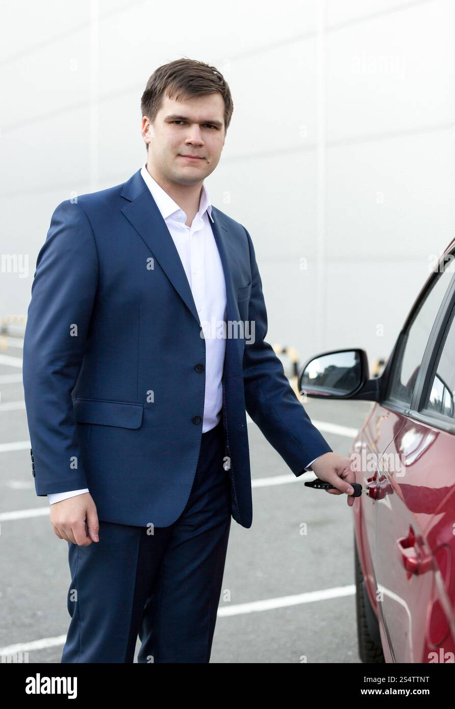 Ritratto di bel giovane imprenditore apertura porta auto Foto Stock