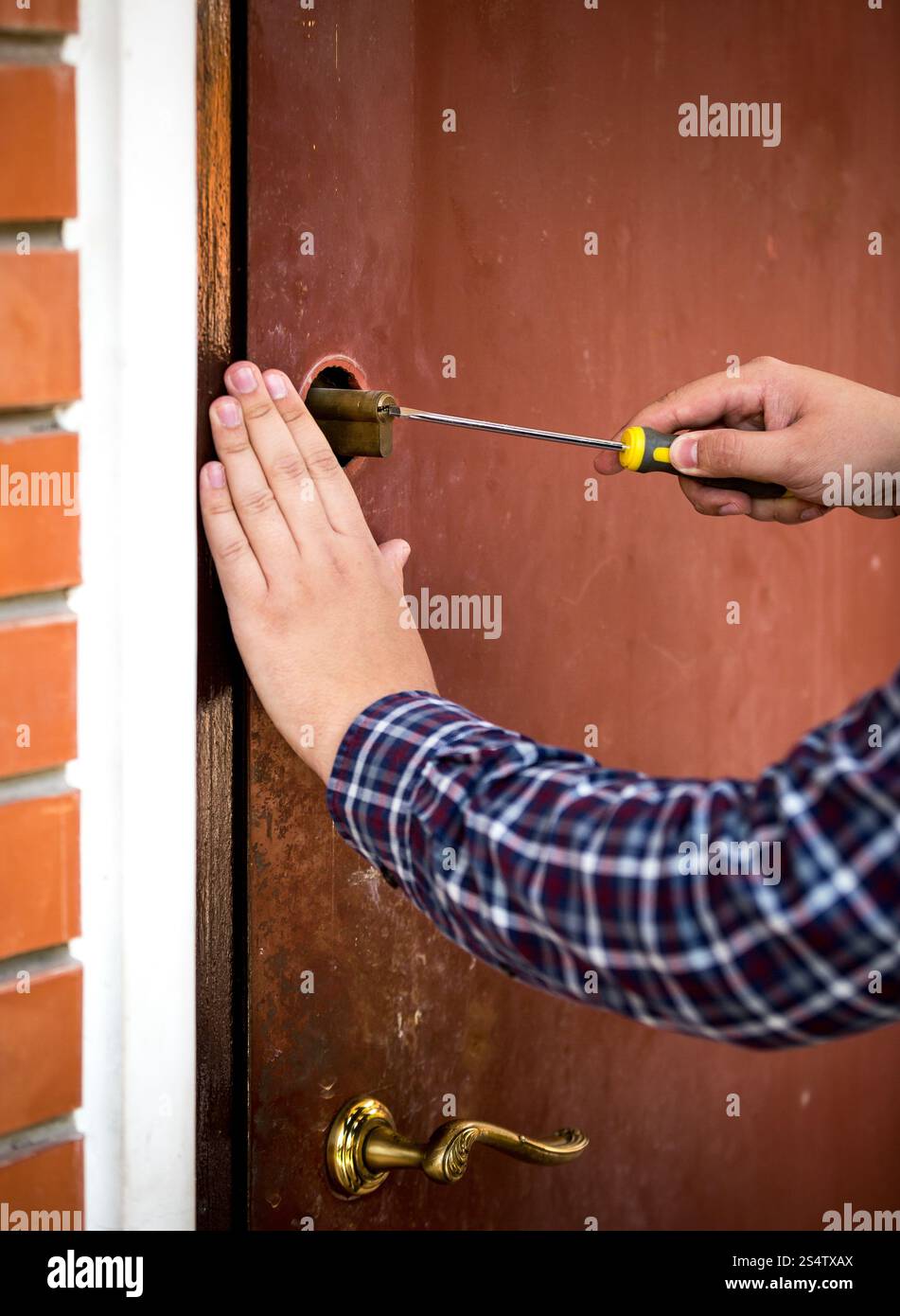 Closeup colpo di falegname che fissa la serratura della porta con un cacciavite Foto Stock